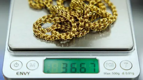 A close up of a gold chain on a set of scales in a jeweller in Hatton Gardens