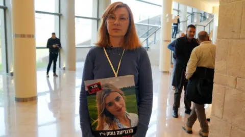 Dr Valentina Gusak holds a picture of her daughter in the Knesset. Her daughter was killed by Hamas on 7 October 2023