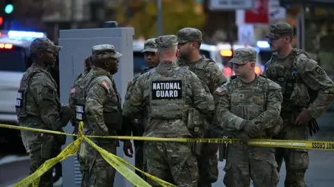 National Guard soldiers gather near a crime scene after a shooting in downtown Washington, DC.