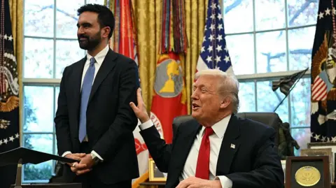 Trump slaps Mamdani's arm in the Oval Office behind the desk.