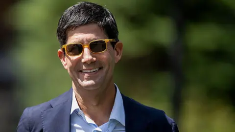 Kevin Warsh, former governor of the US Federal Reserve, wearing sunglasses and smiling at the Allen & Co. Media and Technology Conference in Sun Valley, Idaho, US, on Wednesday, July 9, 2025.