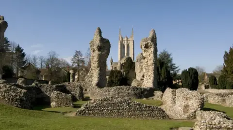 The ruins of the abbey in Bury St Edmunds with the cathedral behind.
