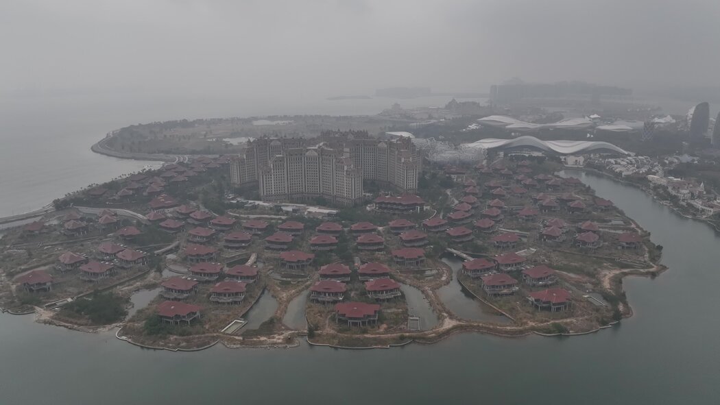 中國海南的海花島項目佔地廣闊,包括一座購物中心、一座會議中心、多棟高層公寓以及一座酒店,四周環繞著數十棟未完工的別墅。